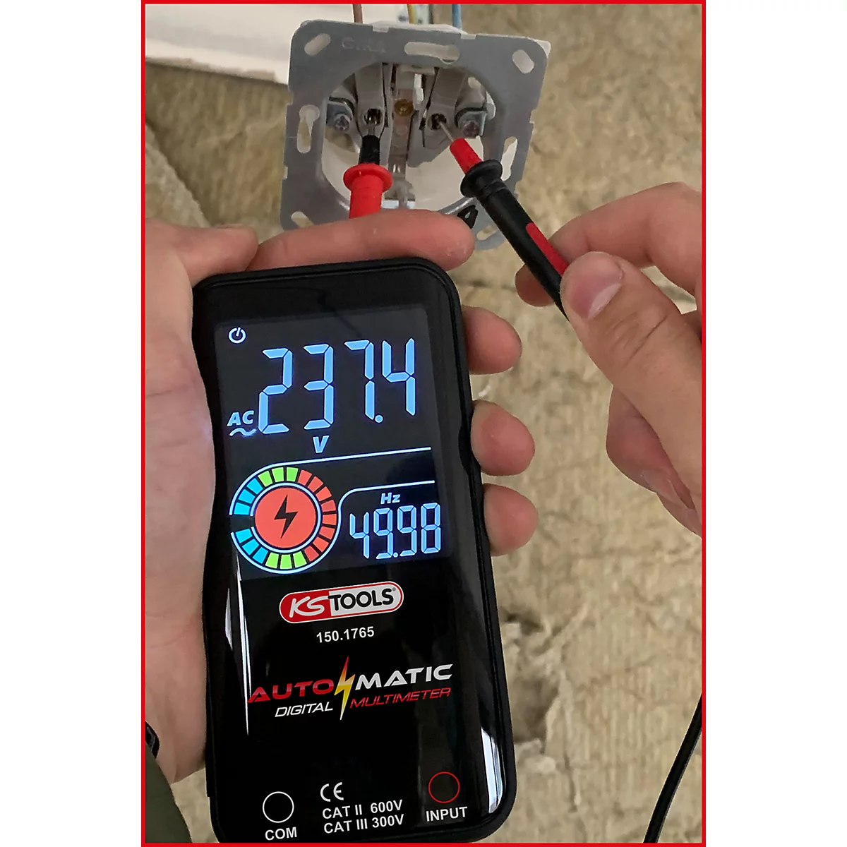 Ein Multimeter misst die Spannung einer Steckdose, 237,4V werden angezeigt. Rote und schwarze Messspitzen sind in der Steckdose positioniert.
